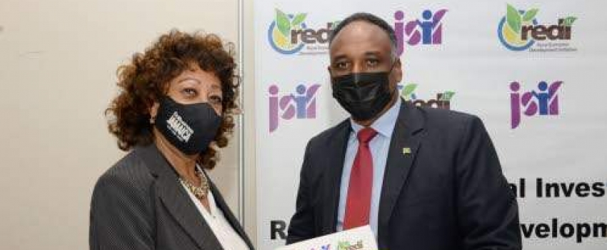 Diane Edwards, president of Jampro, and Omar Sweeney, managing director of the JSIF, display the signed memorandum of understanding between JSIF- Rural Economic Development Initiative II (REDI II) and Jampro at the signing ceremony held at Jamaica Pegasus in Kingston on Wednesday, December 8.