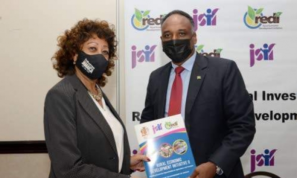 Diane Edwards, president of Jampro, and Omar Sweeney, managing director of the JSIF, display the signed memorandum of understanding between JSIF- Rural Economic Development Initiative II (REDI II) and Jampro at the signing ceremony held at Jamaica Pegasus in Kingston on Wednesday, December 8.