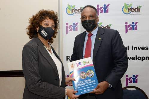 Diane Edwards, president of Jampro, and Omar Sweeney, managing director of the JSIF, display the signed memorandum of understanding between JSIF- Rural Economic Development Initiative II (REDI II) and Jampro at the signing ceremony held at Jamaica Pegasus in Kingston on Wednesday, December 8.