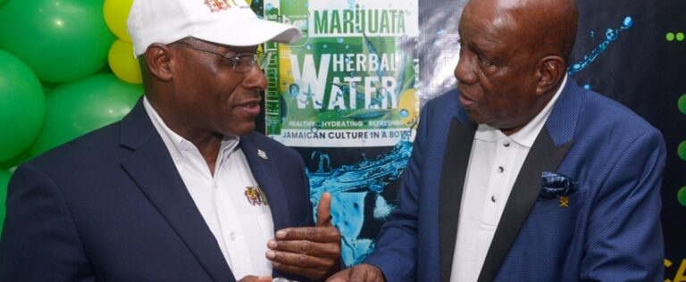 Industry, Investment and Commerce Minister, Senator the Hon. Aubyn Hill (left), speaks to Executive Chairman of the Agency for Innercity Renewal (AIR) Limited, Dr. Henley Morgan about the ‘Marijuwata’ bottled water, which the organisation launched on Tuesday (April 22) at Spike Industries Limited’s Winward Road manufacturing plant in Kingston.