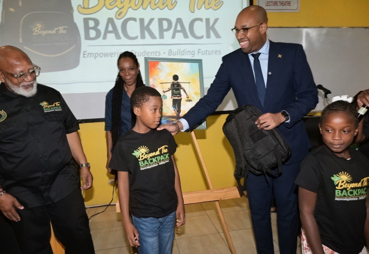 State Minister in the Ministry of Industry, Investment and Commerce, Hon. Delano Seiveright (second right), interacts with Lucea Primary School student, Elsworth Marriott (centre), and Sheffield Primary School student, Kacy Spence, during the launch of the 'Beyond the Backpack' initiative on Tuesday (August 11), at The University of the West Indies (UWI), Mona Campus, in St. Andrew. Also pictured are Founder, President and Chief Executive Officer of Global Humanity Network Inc., Dr. Laxley Stephenson (left), and visual artist Romaine McNeil.