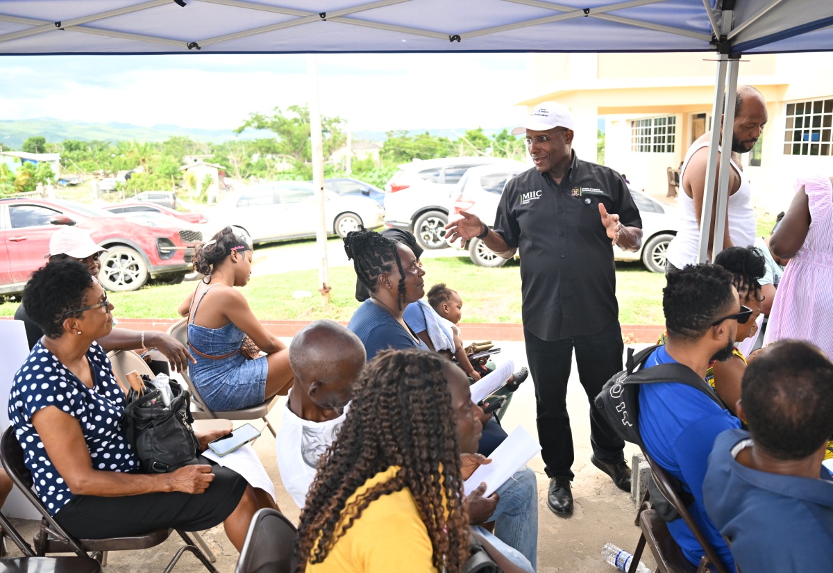Industry, Investment and Commerce Minister, Senator the Hon. Aubyn Hill (standing), speaks with applicants during the MSME Restoration Grant Programme Application Drive at the Black River Independent Baptist Church in St. Elizabeth on Wednesday, October 14.