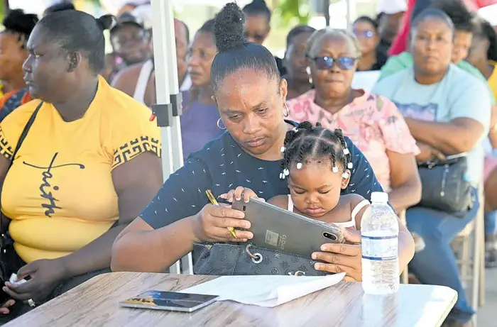 A Black River resident uses a tablet to complete her online application for the Ministry of Industry, Investment and Commerce (MIIC) MSME Restoration Grant Programme, during the application drive at Black River Independent Baptist Church, St Elizabeth, on Wednesday. The online application is facilitated through the Gov Payout platform, powered by the Information and Communications Technology Authority.